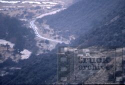 Scenic mountain road with a truck, showcasing natural landscape and transportation infrastructure. Mountain road with truck in a hilly landscape, scenic view of winding road and natural terrain.