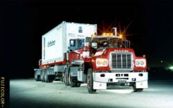 A Mack truck transporting a container during nighttime, emphasizing reliable freight transport services. Heavy-duty Mack truck hauling a container at night, showcasing robust logistics and transport soluti.