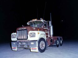 A classic Mack truck displayed at night, emphasizing its robust build and suitability for heavy freight hauling. Mack heavy-duty truck parked on a dark night, showcasing durability and power for freight transport.