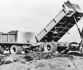 noddy train Heavy machinery dump truck unloading soil or gravel at a construction site.